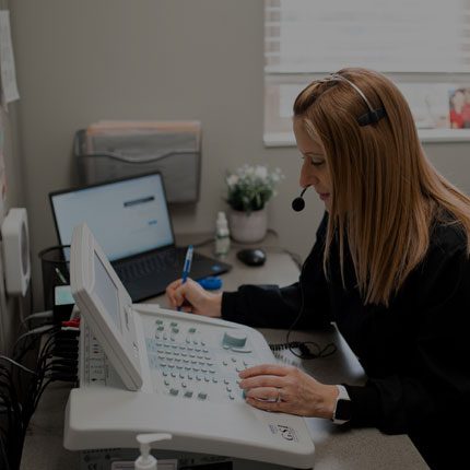 Audiologist working with a device