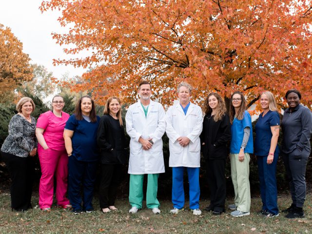 Practice team standing beside two doctors